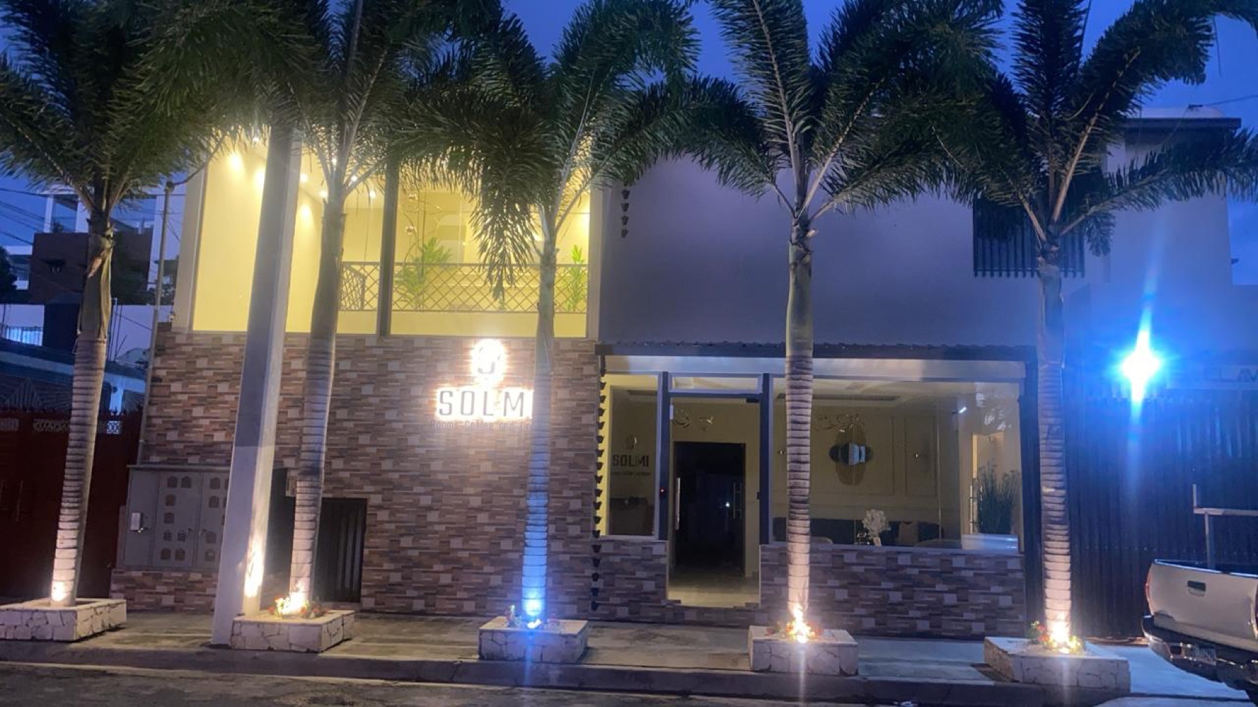 Fachada de Solmi Rooms iluminada por la noche
